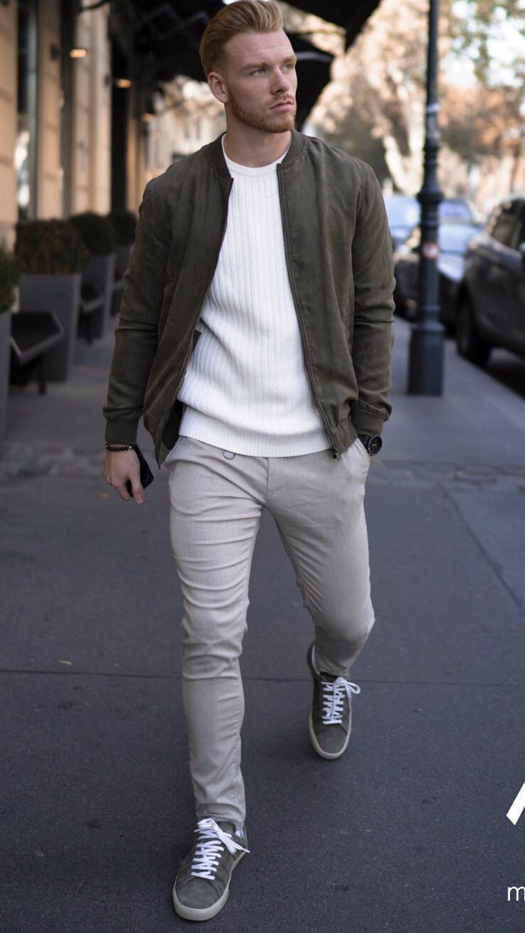 man wearing beige pants, white sweater and army green bomber jacket